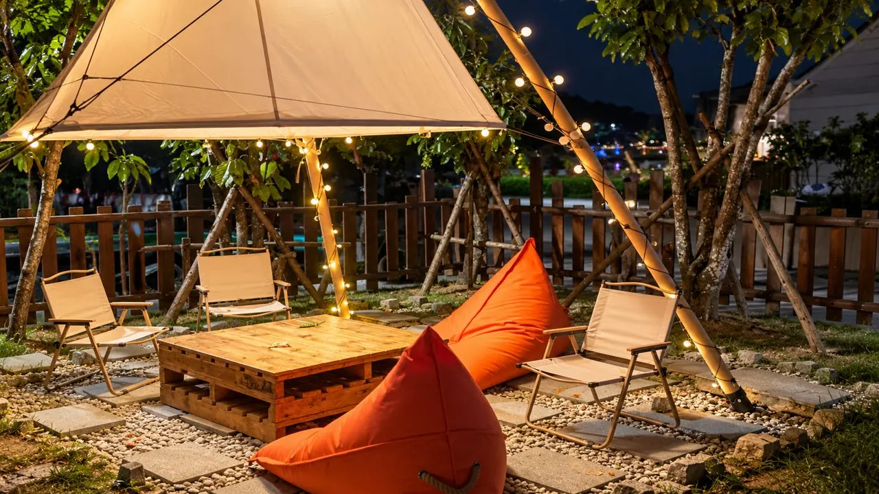 Garden lounge with canvas canopy, bean bags and string lights at dusk